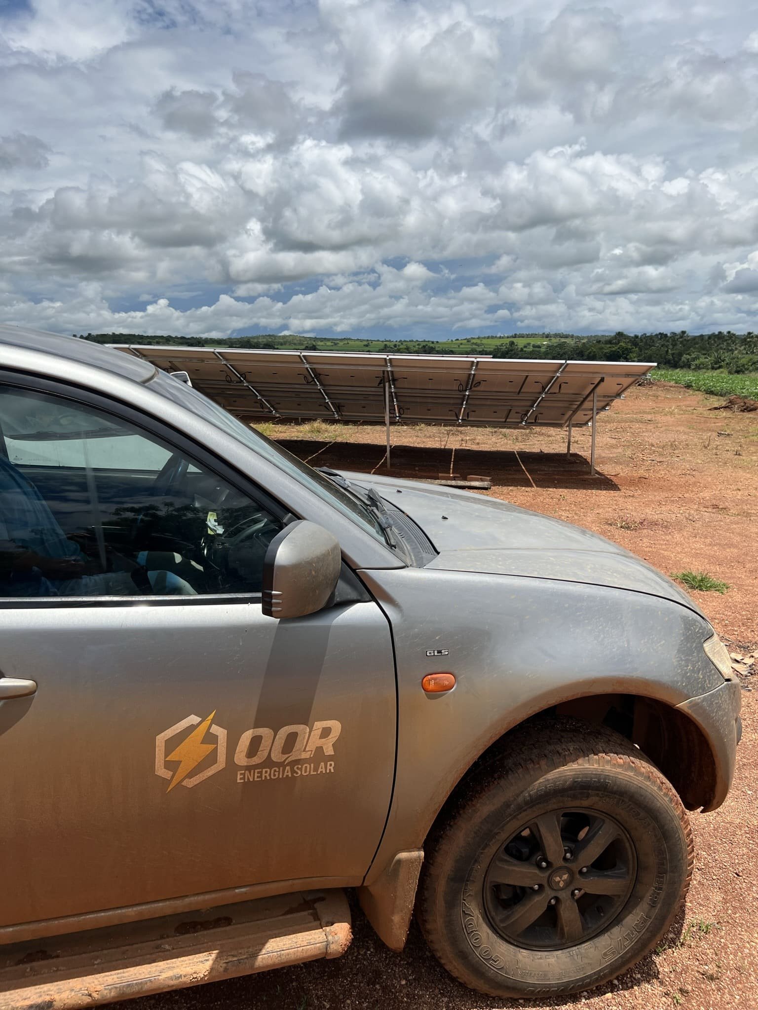 Caminhonete da OQR em frente a uma usina solar de solo